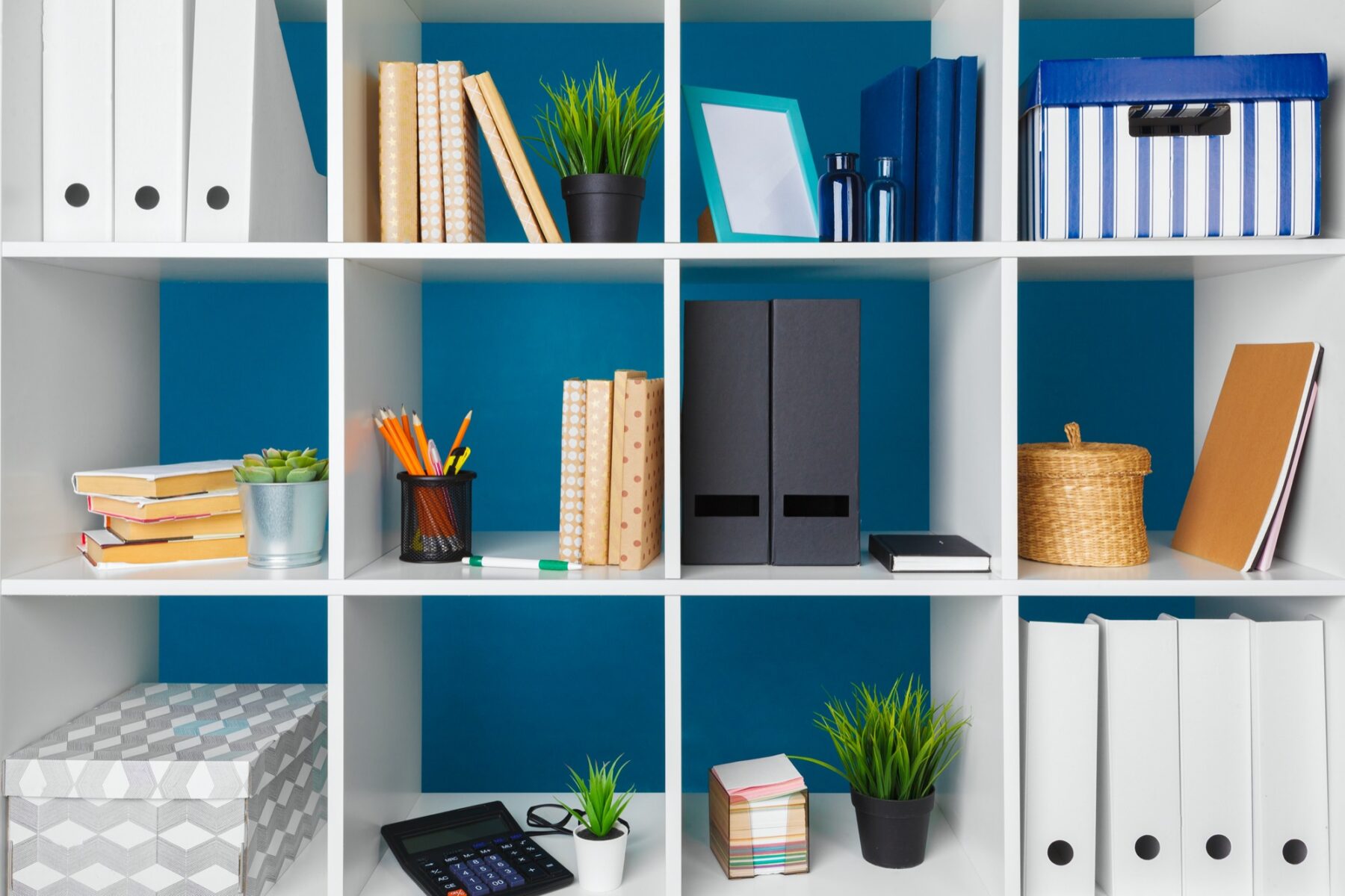 White office shelves with different stationery, close up